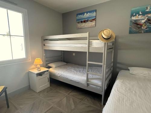 - une chambre avec 2 lits superposés et un chapeau dans l'établissement Maison de vacances avec jardin clos, à proximité de la plage de Barbâtre, 6 couchages - FR-1-224B-227, à Barbâtre