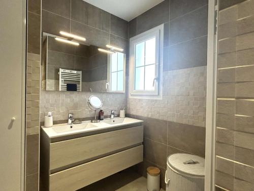 une salle de bain avec un lavabo et un miroir et des toilettes dans l'établissement Maison de vacances avec jardin clos, à proximité de la plage de Barbâtre, 6 couchages - FR-1-224B-227, à Barbâtre