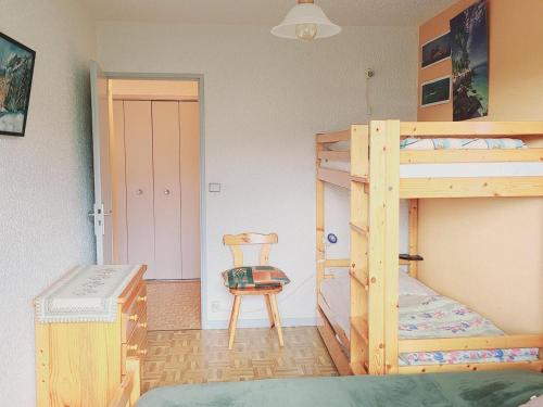 - une chambre avec 2 lits superposés et une chaise dans l'établissement Appartement 2 pièces avec balcon plein sud, 6 couchages, parking privatif, proche centre Villard-de-Lans - FR-1-689-132, à Villard-de-Lans