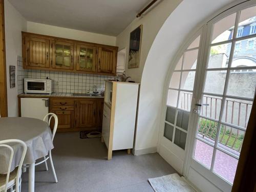 une cuisine avec une table et un réfrigérateur blanc dans l'établissement Bel Appartement en Centre, 1 Ch, Près Télécabines - FR-1-234-317, à Cauterets