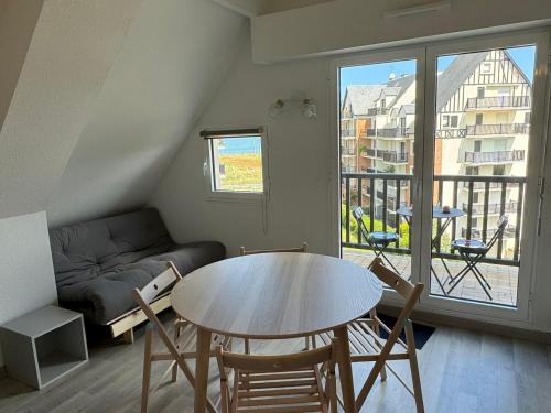 un salon avec une table et un canapé dans l'établissement Appartement rénové 2 pièces, face mer, Cabourg - FR-1-487-369, à Cabourg