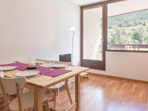 une salle à manger avec une table en bois et une grande fenêtre dans l'établissement Studio rénové avec balcon sud, skis aux pieds, parking et grand jardin, La Salle-les-Alpes - FR-1-330F-237, à La Salle Les Alpes