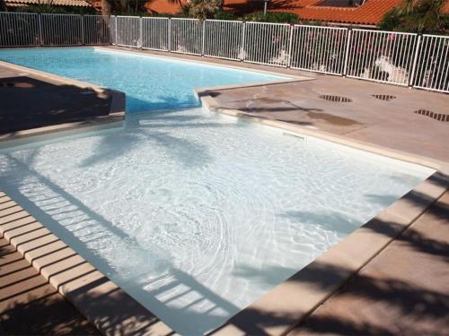 une grande piscine avec un liquide clair dedans dans l'établissement Charmante Villa T3 avec Piscine, Terrasse et Parking pour 6 Personnes à Port Barcarès - FR-1-81-619, au Barcarès