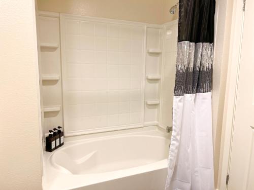 a bathroom with a white tub and a shower at Cozy Home in LA - Free Parking 10 Min to Cedars in Los Angeles
