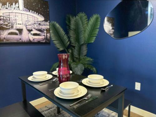a black table with plates and utensils on it at Cozy Home in LA - Free Parking 10 Min to Cedars in Los Angeles