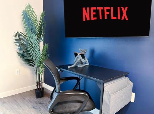 a desk with a chair and a tv on a blue wall at Cozy Home in LA - Free Parking 10 Min to Cedars in Los Angeles