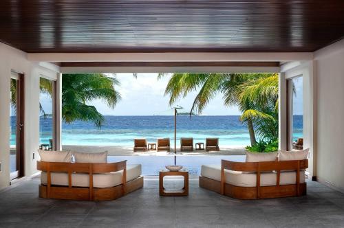 a living room with a view of the ocean at Huvafen Fushi Maldives in North Male Atoll