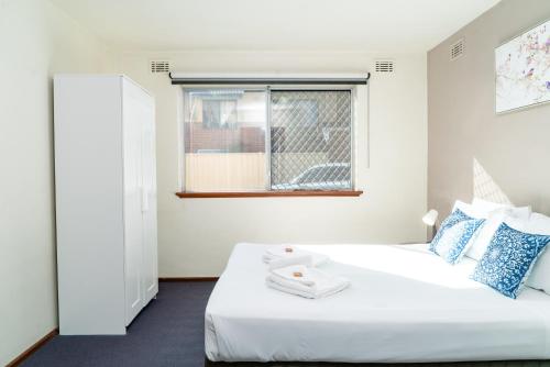 パースにあるApartment 3 Burswoodのベッドと窓のある白い寝室