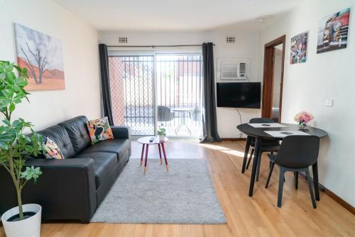 a living room with a black couch and a table at Apartment 3 Burswood in Perth