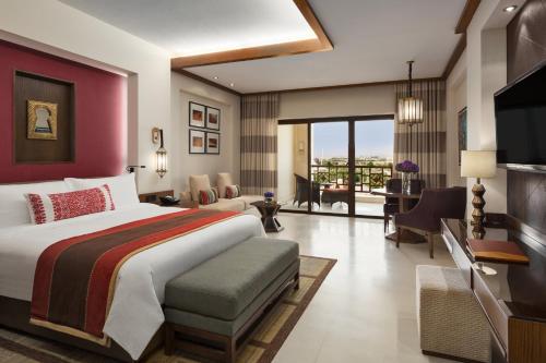 a bedroom with a large bed and a living room at InterContinental Durrat Al Riyadh Resort & Spa by IHG in Riyadh