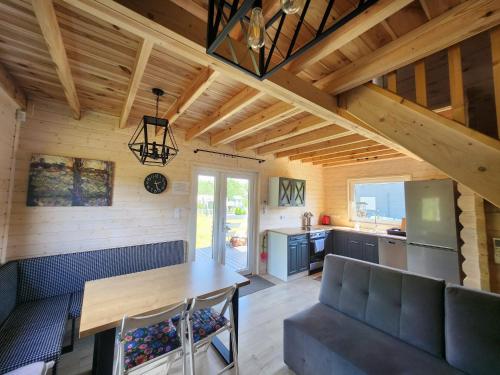 a kitchen and living room in a log cabin at Szary Domek 4 jacuzzi kominek klimatyzacja jezioro in Trojaczek