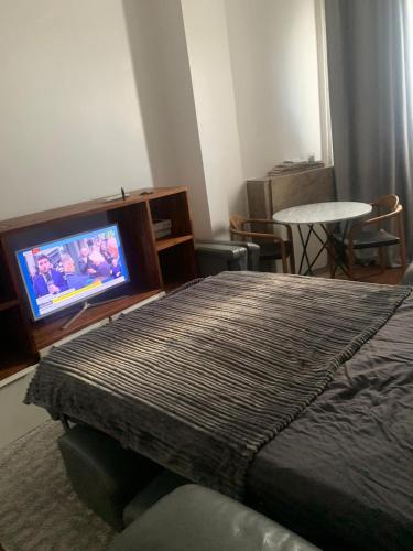 une chambre avec un lit et une télévision à écran plat dans l'établissement Paris, à Aubervilliers