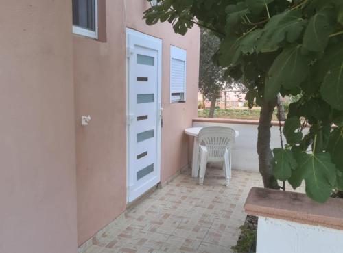 a door leading to a patio with a table and a chair at Apartments Rubbi in Vrsi