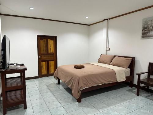 a bedroom with a bed and a desk and a television at Smile Resort in Ban Phai Cham Sin