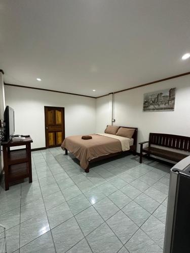a bedroom with a bed and a table and a television at Smile Resort in Ban Phai Cham Sin