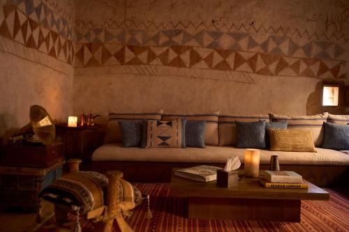 a living room with a couch and a coffee table at Dar Tantora The House Hotel in AlUla