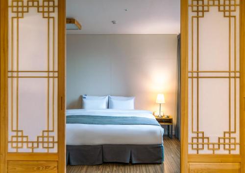 a bedroom with a bed and two glass doors at JK Blossom Hotel in Seoul