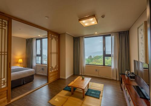 1 dormitorio con 1 cama, TV y mesa en JK Blossom Hotel en Seúl
