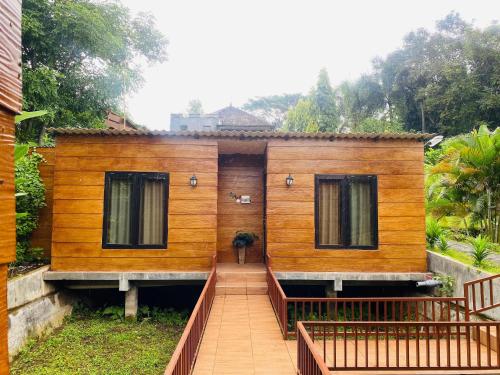 a wooden house with a walkway in front of it at RedDoorz Syariah Near Wisata Durensewu Pandaan in Jetak