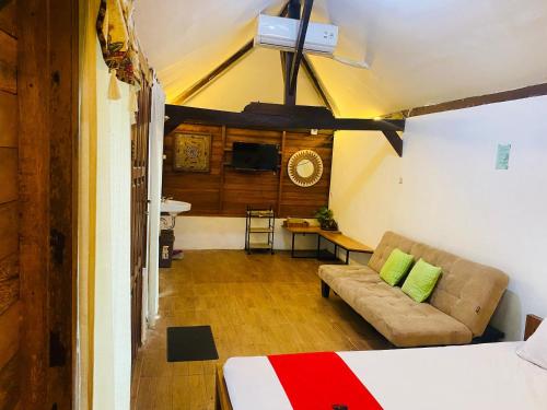 a bedroom with a bed and a couch in a room at RedDoorz Syariah Near Wisata Durensewu Pandaan in Jetak