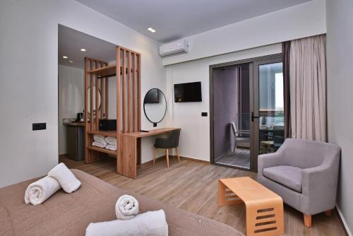 a living room with a bed and a chair and a desk at Dionisos Hotel in Malia