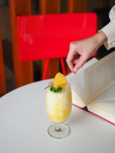 a person is placing an orange slice in a cocktail at Maikaew Damnoen Resort in Damnoen Saduak