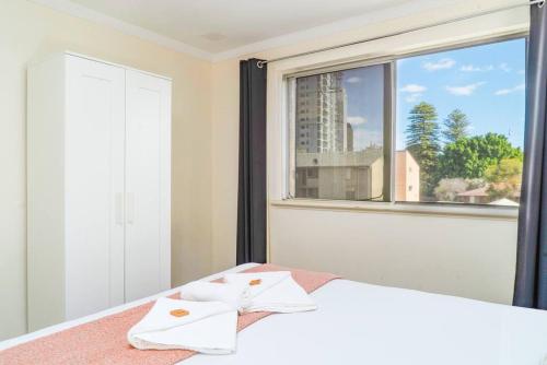 a bedroom with a bed and a large window at Apartment 9 in Perth