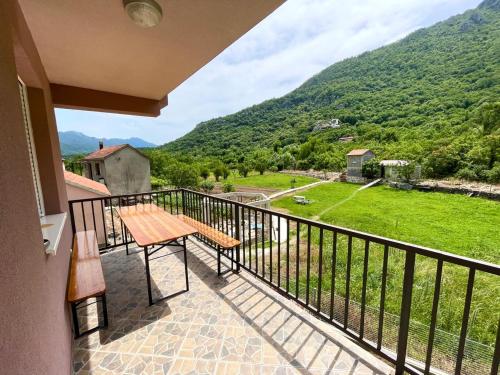 uma varanda com um banco e vista para uma montanha em Riverside em Virpazar