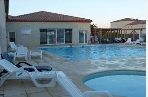 une piscine avec deux chaises longues et une piscine dans l'établissement jasses de Camargues, à Gallargues-le-Montueux