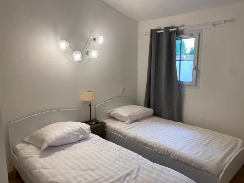 deux lits jumeaux dans une chambre avec fenêtre dans l'établissement jasses de Camargues, à Gallargues-le-Montueux