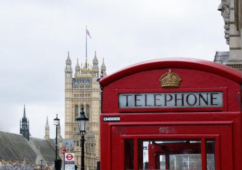 a red telephone booth in front of big ben at The Welbeck Hotel by IHG in London