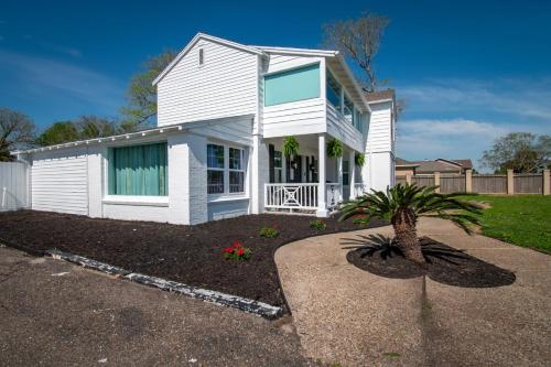 a white house with a palm tree in a driveway at Coastal Elegance Unveiled in Corpus Christi
