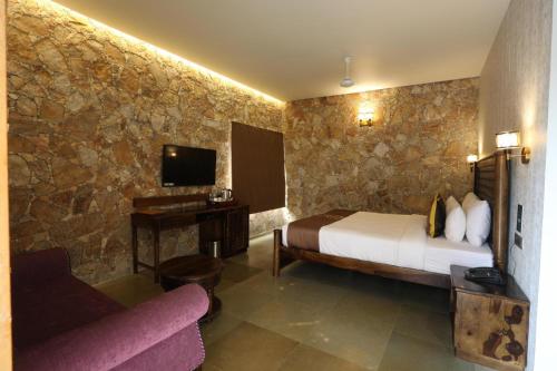 a hotel room with a bed and a couch at Vikrama Heritage Resort Pavagadh in Hālol