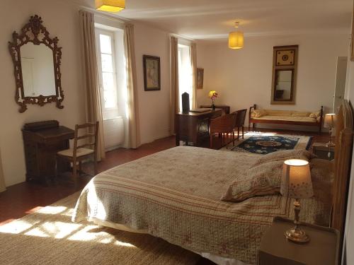 une chambre avec un lit, une table et un bureau dans l'établissement La Grange des Davids Mas en Provence, à Oppedette