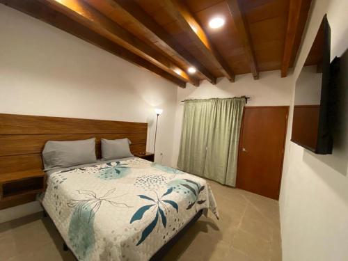 a bedroom with a bed with a wooden head board at Casa de la Abuelita in Oaxaca City