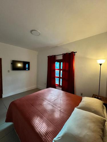 a bedroom with a bed and a window with red curtains at Casa de la Abuelita in Oaxaca City