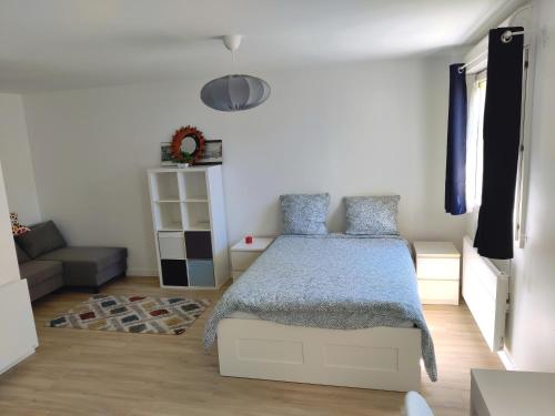 un dormitorio con una cama y un sofá en Calme, tranquille, proche Paris, en Bagneux