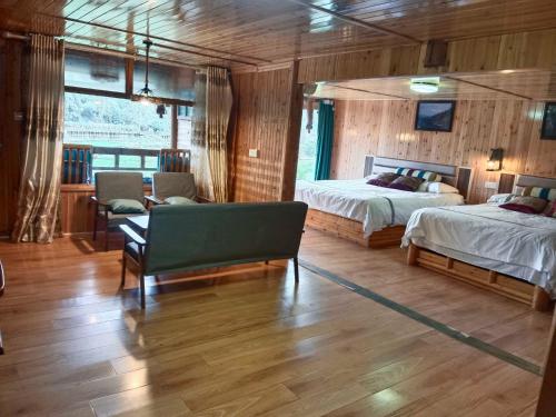 a bedroom with two beds and a couch and a chair at Bridge View Boutique Guesthouse 望桥楼精品民宿 in Sanjiang