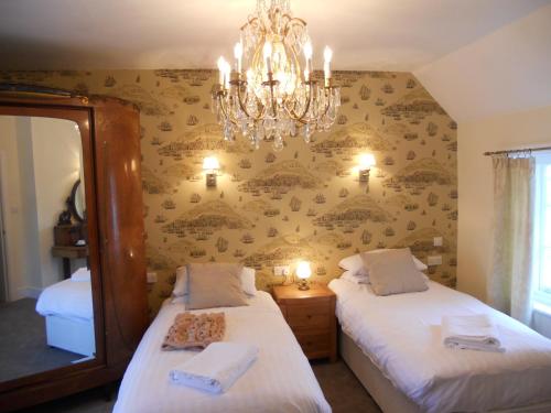 a bedroom with two beds and a chandelier at The Union Inn in Cowes