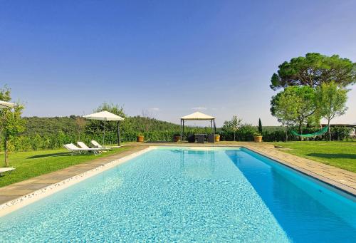 una piscina en un patio con 2 sillas y un columpio en Romina by PosarelliVillas, en Valiano