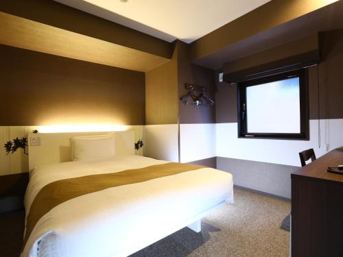 a bedroom with a large bed and a window at Hotel Wing International Select Ueno Okachimachi in Tokyo