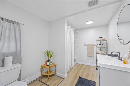 a white bathroom with a sink and a mirror at Riverfront Cottages in Wasaga Beach