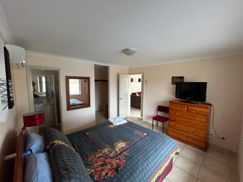 a bedroom with a bed and a tv on a dresser at Geraldton Luxury Vacation Home with free Streaming in Geraldton