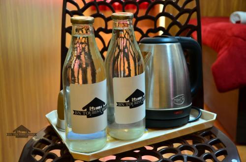 two bottles of wine on a tray with a coffee pot at BN Tourist Home in Ooty