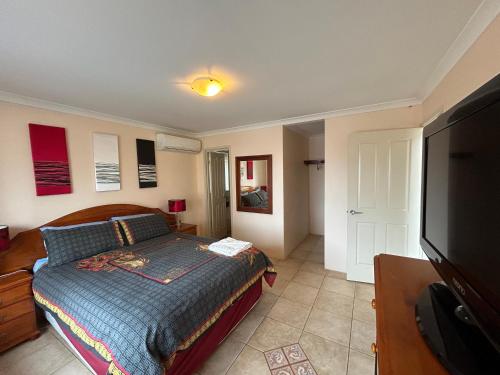 a bedroom with a bed and a flat screen tv at Geraldton Luxury Vacation Home with free Streaming in Geraldton