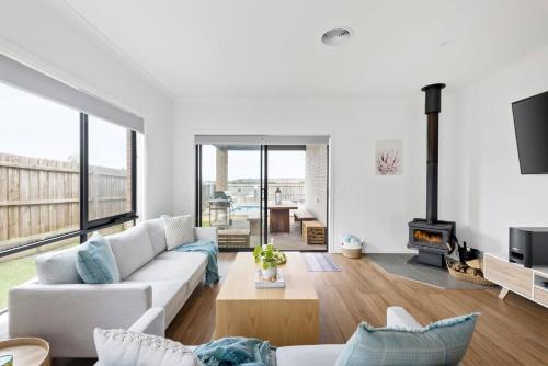 a living room with a white couch and a fireplace at Thyme Out in Cowes