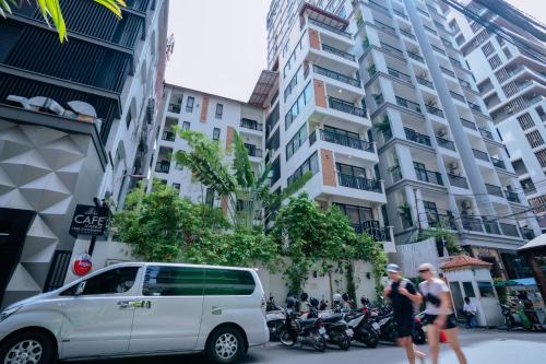 a white van parked on a city street with motorcycles at Home Chic Hotel in Phnom Penh