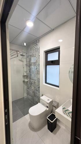 a bathroom with a toilet and a glass shower at Homestay BỒ CÔNG ANH in Da Lat