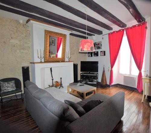 - un salon avec un canapé et des rideaux rouges dans l'établissement Atypique, à La Roche-Posay