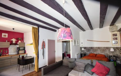 un salon avec un canapé et un lit dans l'établissement Atypique, à La Roche-Posay